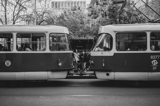 Černobílá momentka ze zastávky Jindřišská v Praze zobrazující spojení dvou tramvají.