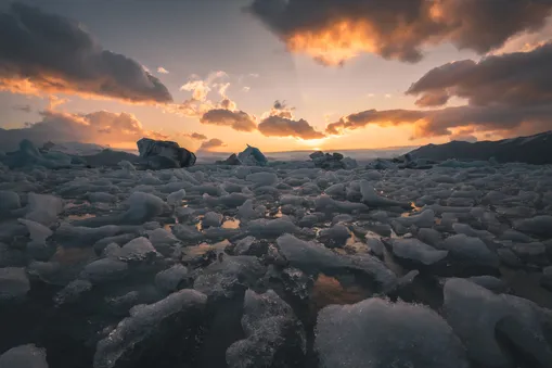 Ledové kry v ledovcové laguně Jökulsárlón na Islandu během zářivého západu slunce.