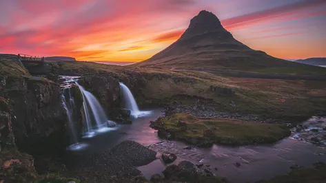 Islandská hora Kirkjufell s vodopádem v popředí při západu slunce.