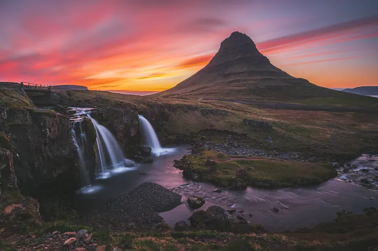 Islandská hora Kirkjufell s vodopádem v popředí při západu slunce.