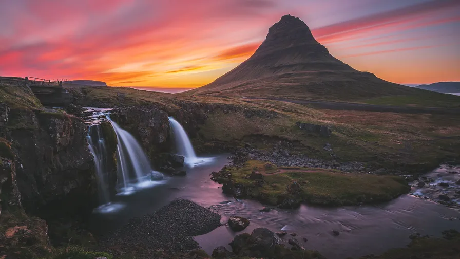 Islandská hora Kirkjufell s vodopádem v popředí při západu slunce.